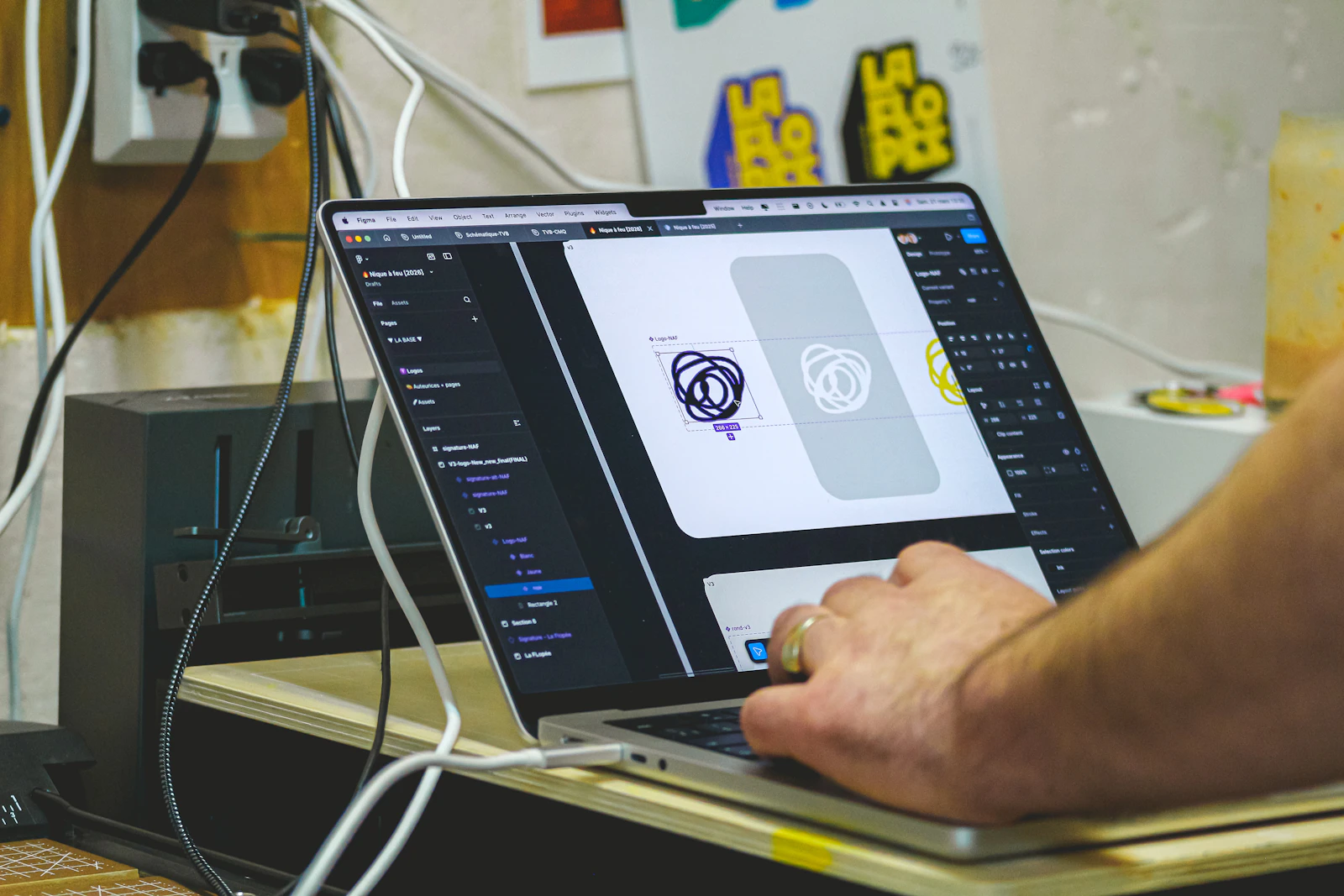 Designer creating logo artwork on a laptop Person creating a visual design on a laptop
