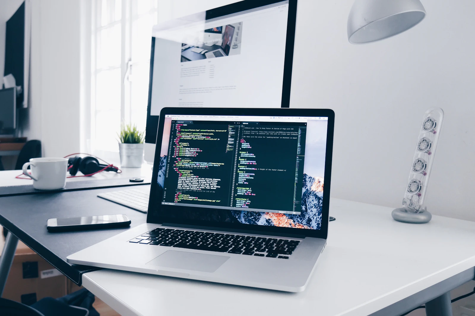 Web development code on a laptop Laptop displaying code on a wooden desk